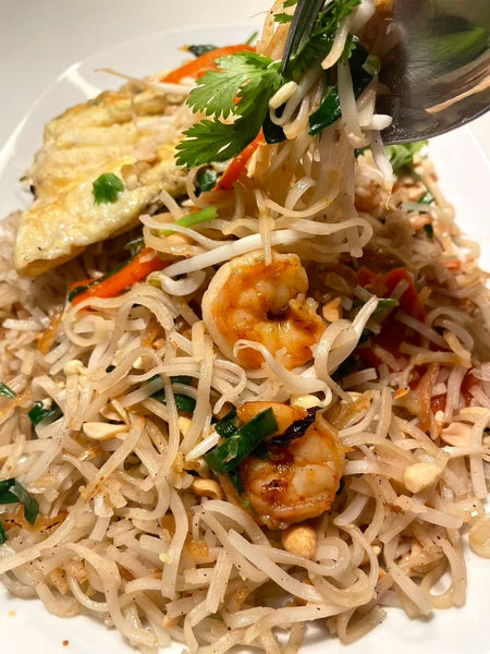 Pad thai-nudler med hvidløgblade, tigerrejer og pad thai paste